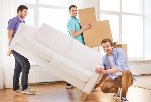 Professional movers carrying furniture in a Highbury apartment building