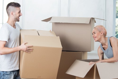 Professional movers carrying furniture down stairs in a Highbury flat